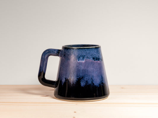 Blue ceramic mug on a wooden surface with a white background