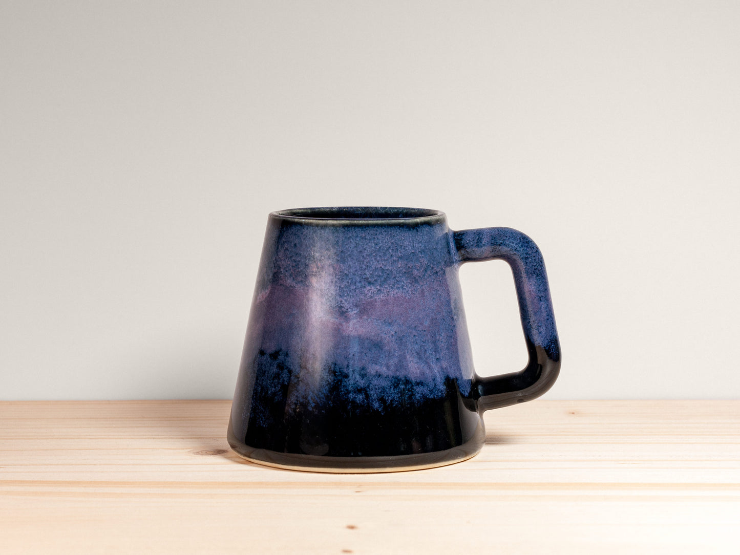 Blue ceramic mug on a wooden surface with a white background