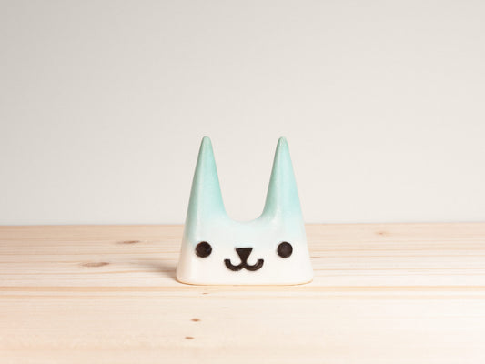 Ceramic cat-shaped ring holder on a wooden surface