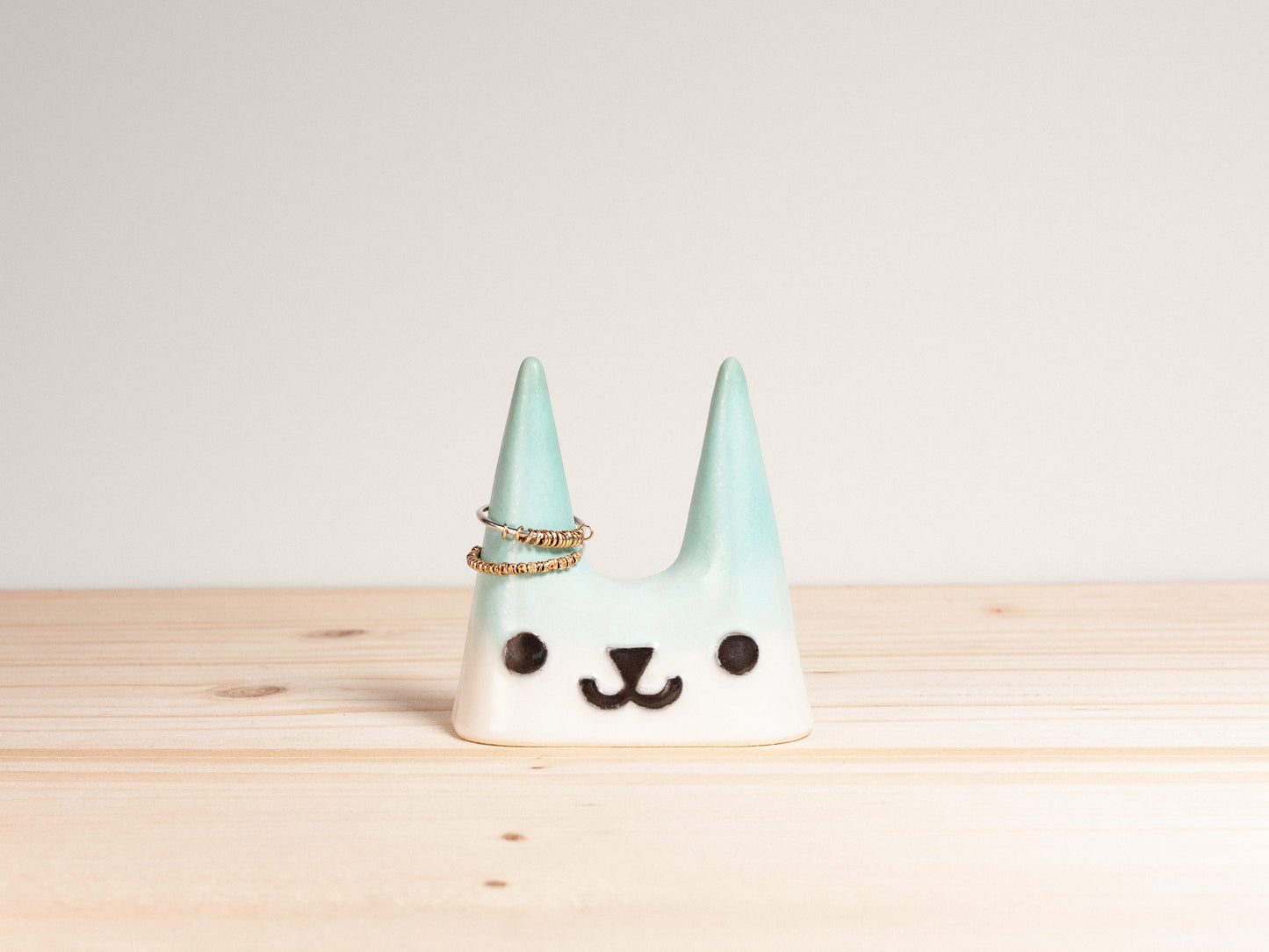 Ceramic cat-shaped ring holder on a wooden surface