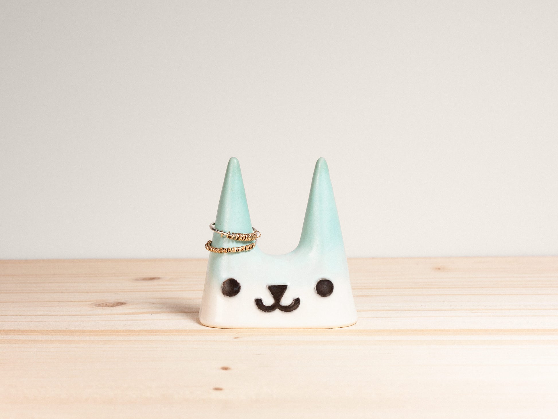 Ceramic cat-shaped ring holder on a wooden surface