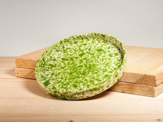 Green speckled ceramic plate on a wooden surface