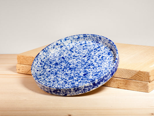 Blue speckled ceramic plate on a wooden surface