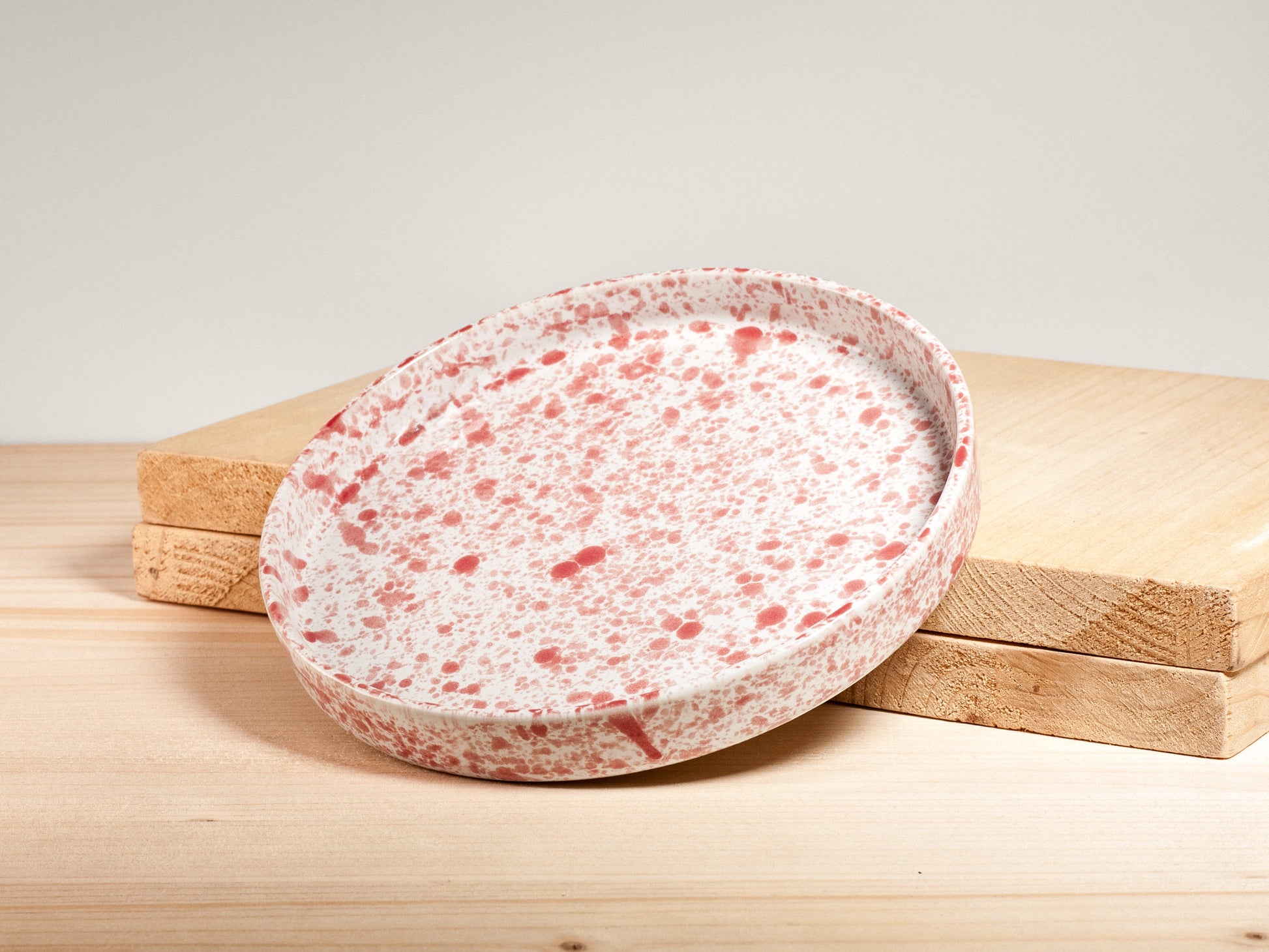 Speckled ceramic plate on a wooden surface with a light background