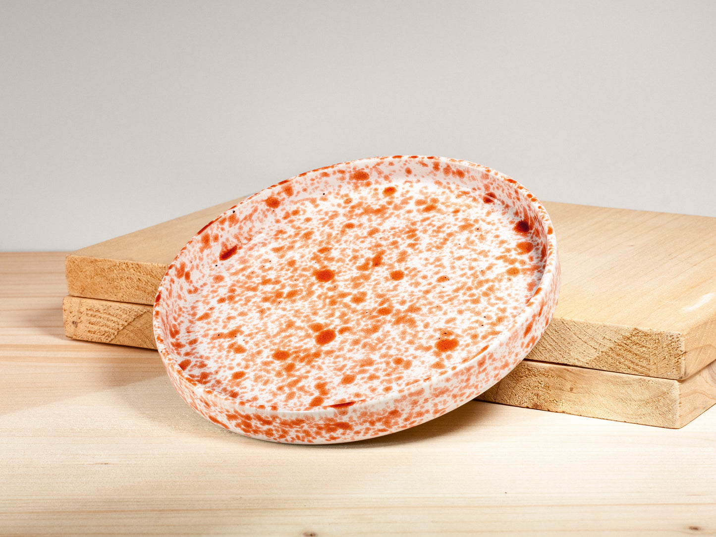 Speckled ceramic plate on a wooden surface with a neutral background