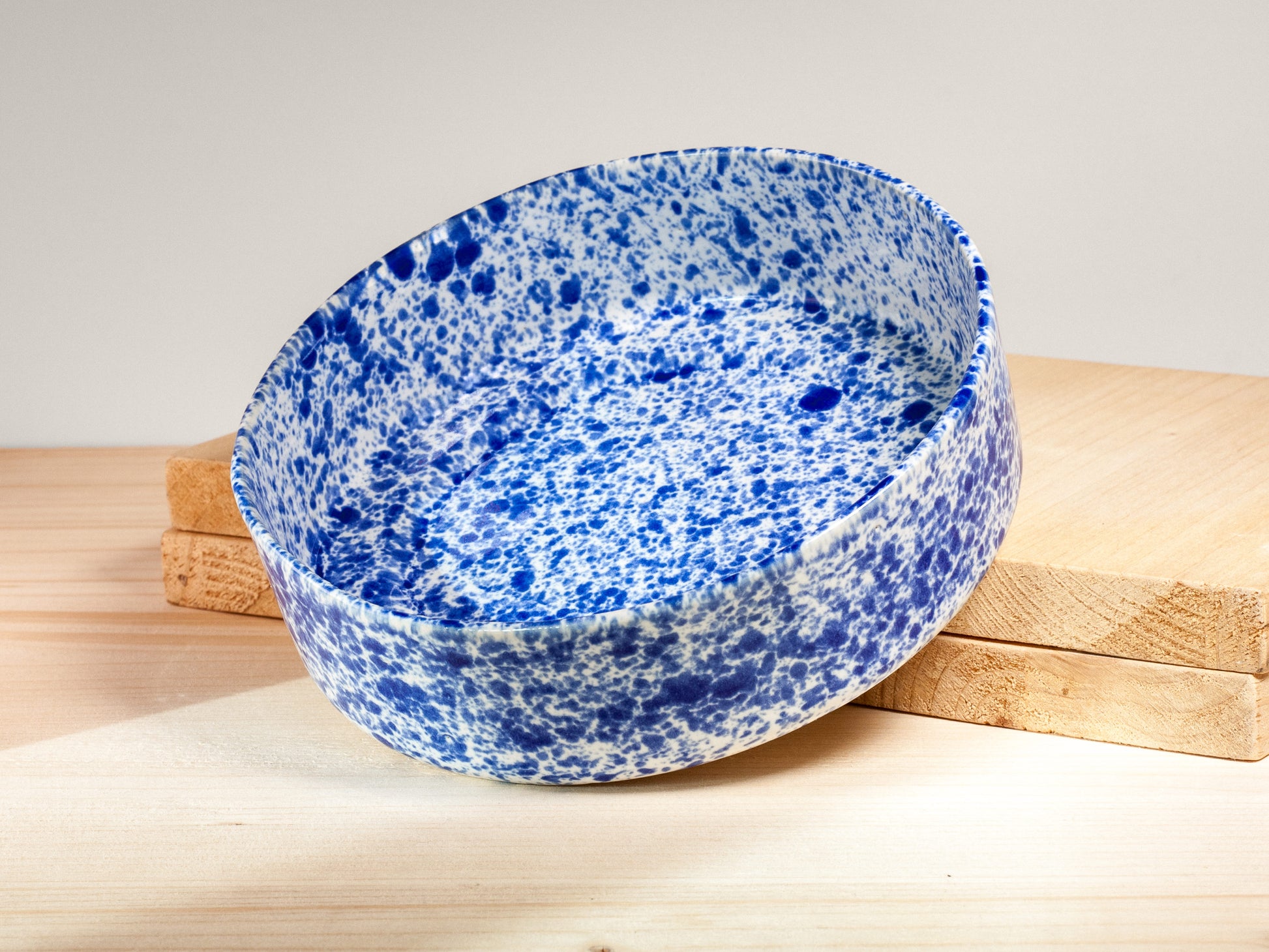 Blue and white speckled ceramic bowl on a wooden surface