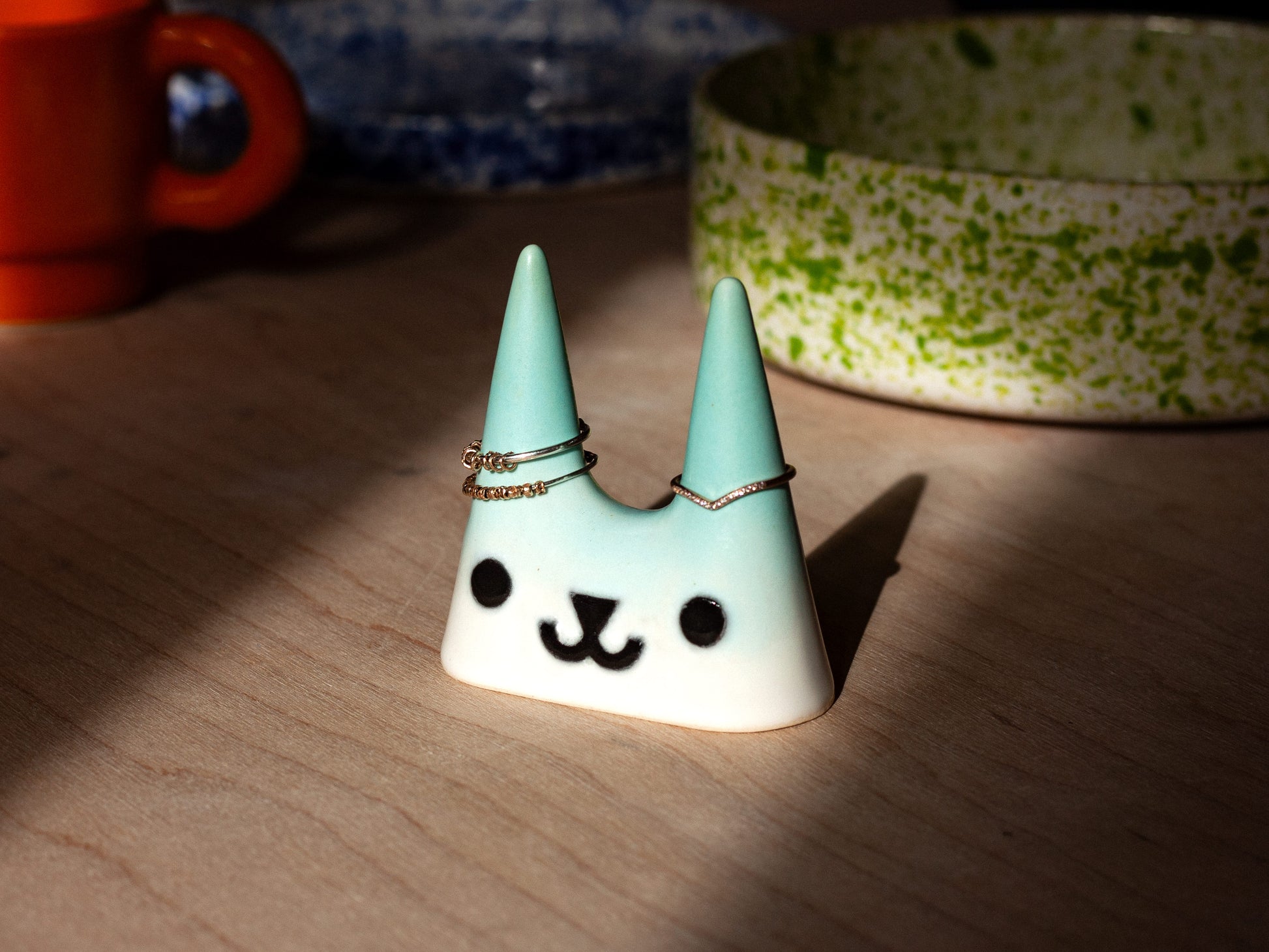 Ceramic cat-shaped ring holder on a wooden surface