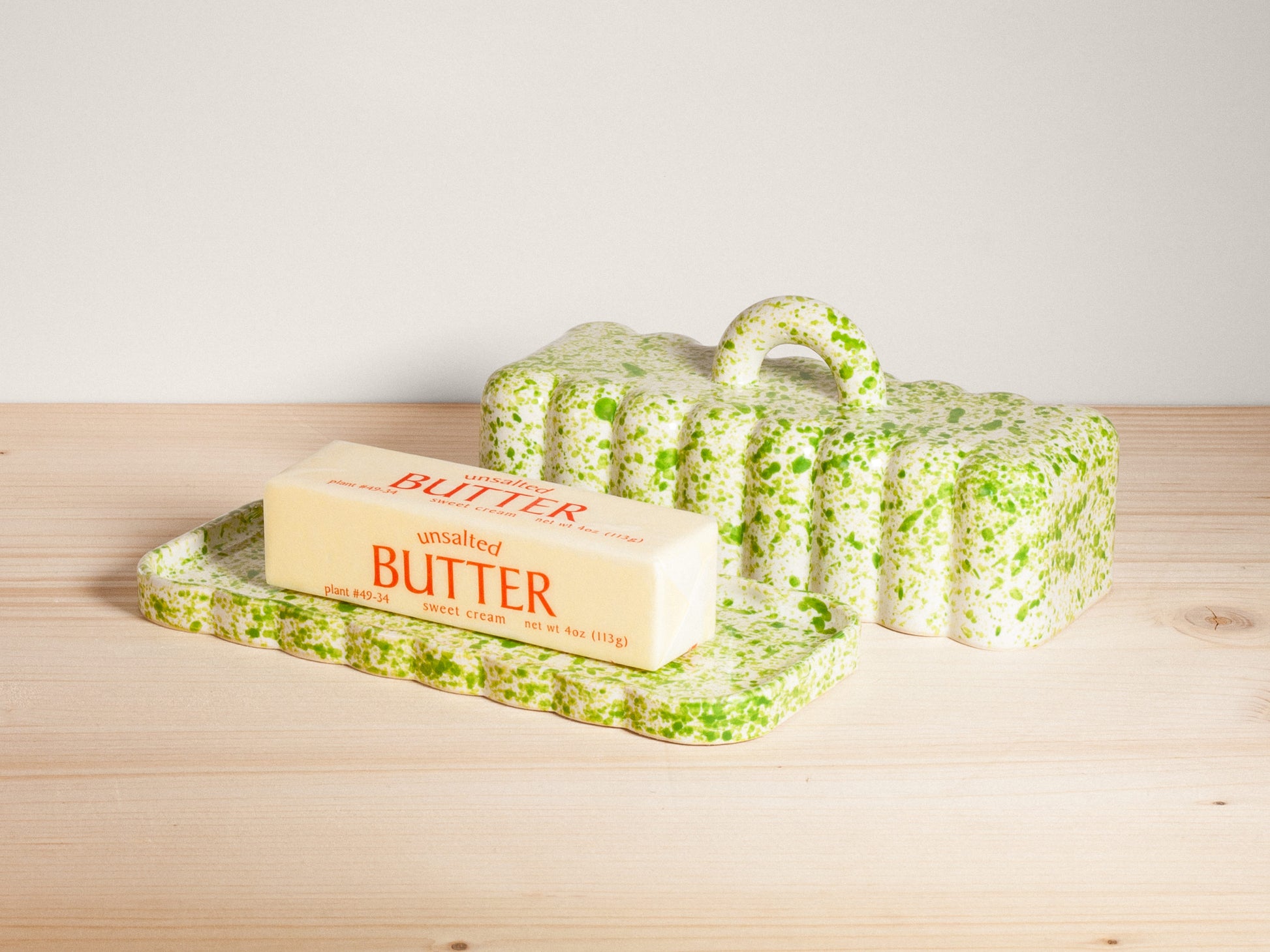 Butter dish with a stick of butter on a wooden surface