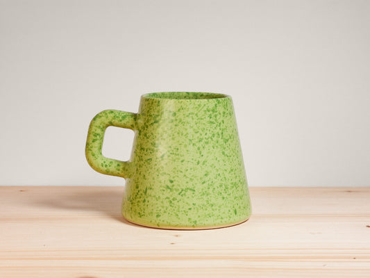 Green ceramic mug on wooden surface