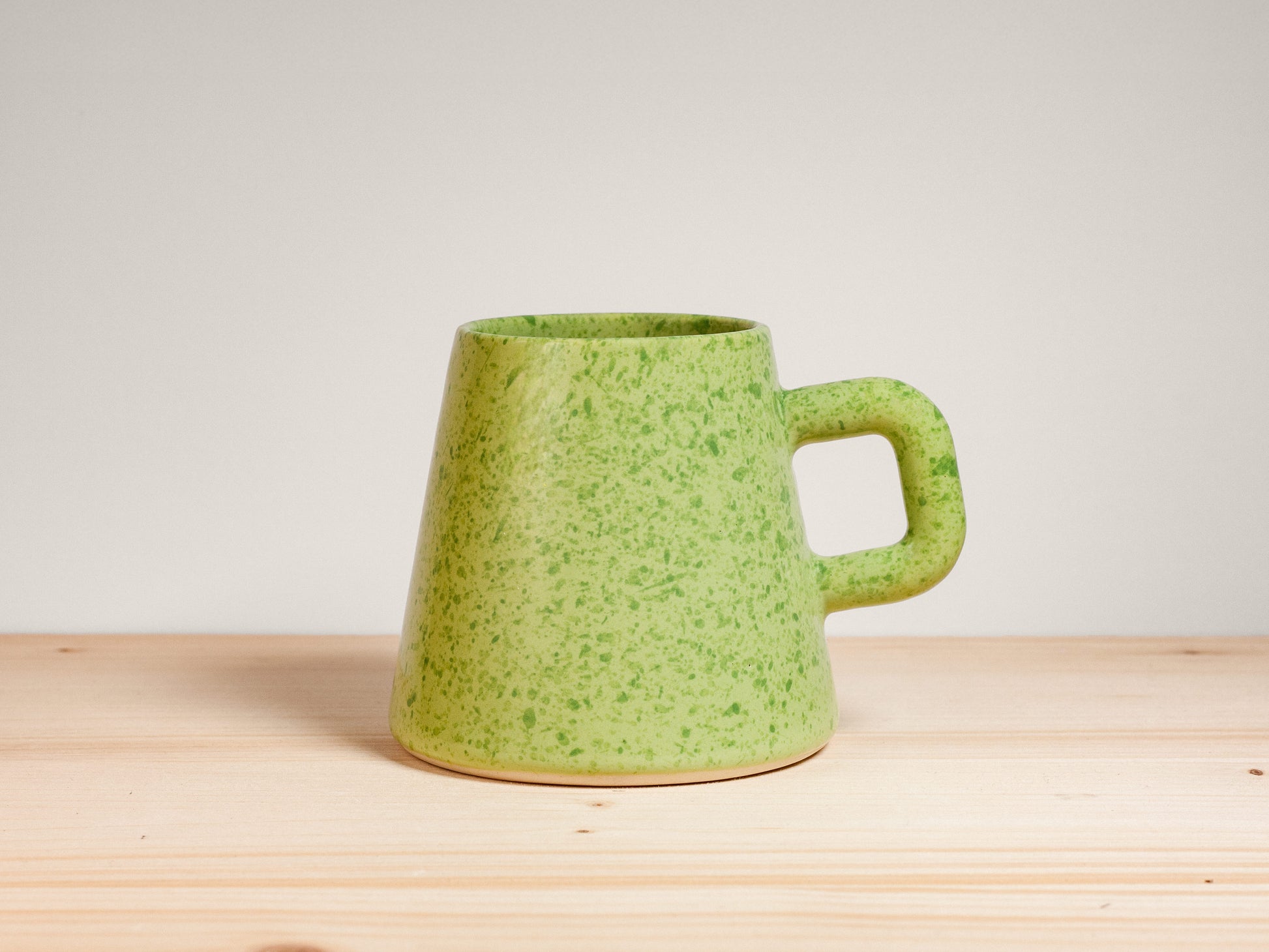 Green ceramic mug on wooden surface
