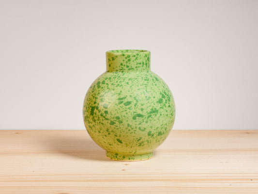 Green ceramic vase on wooden surface