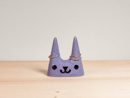 Purple cat-shaped ceramic ring holder on wooden surface