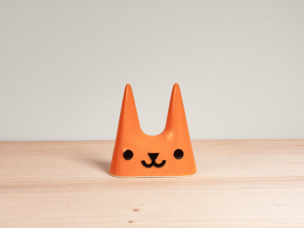 Orange cat-shaped ceramic ring holder on wooden surface