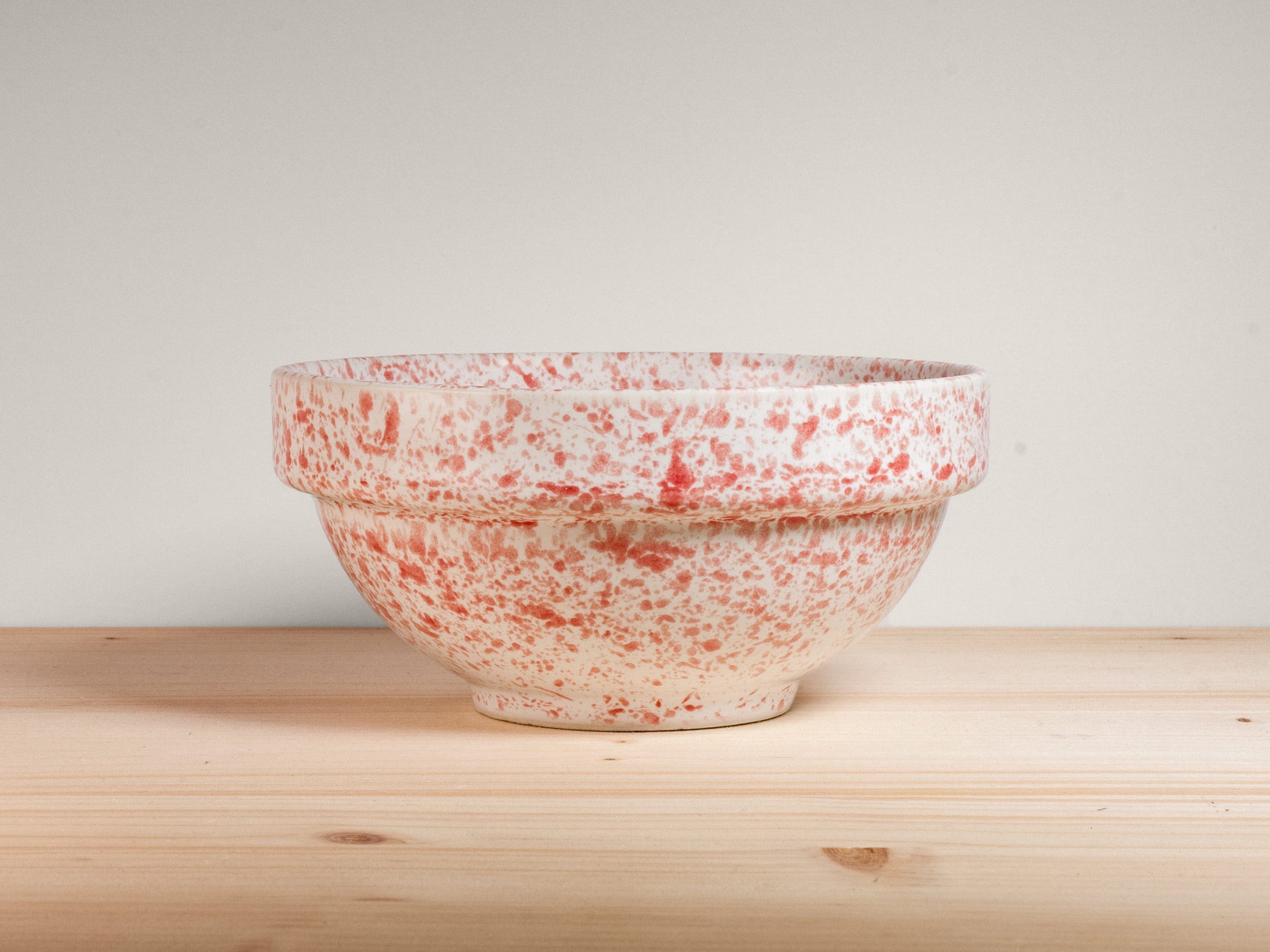 Pink and white ceramic bowl on wooden surface