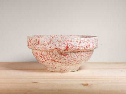 Pink and white ceramic bowl on wooden surface