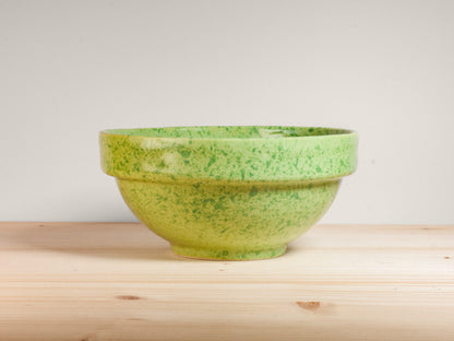 Green ceramic bowl on wooden surface