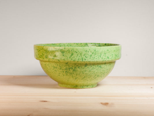 Green ceramic bowl on wooden surface