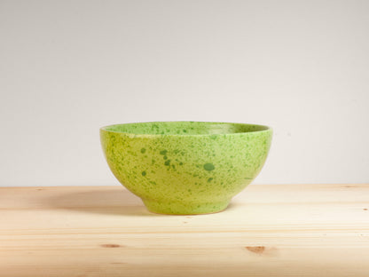 Green ceramic bowl on wooden surface
