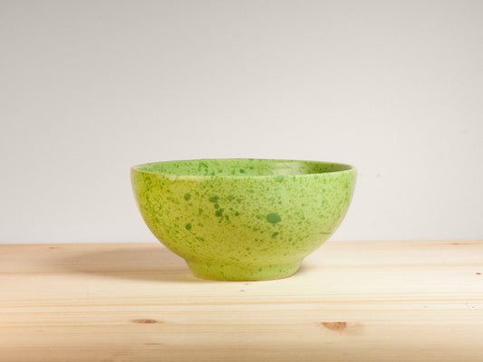 Green ceramic bowl on wooden surface