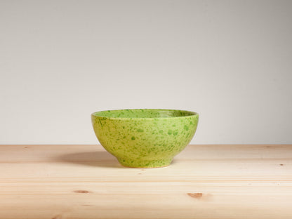 Green ceramic bowl on wooden surface