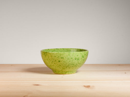 Green ceramic bowl on wooden surface