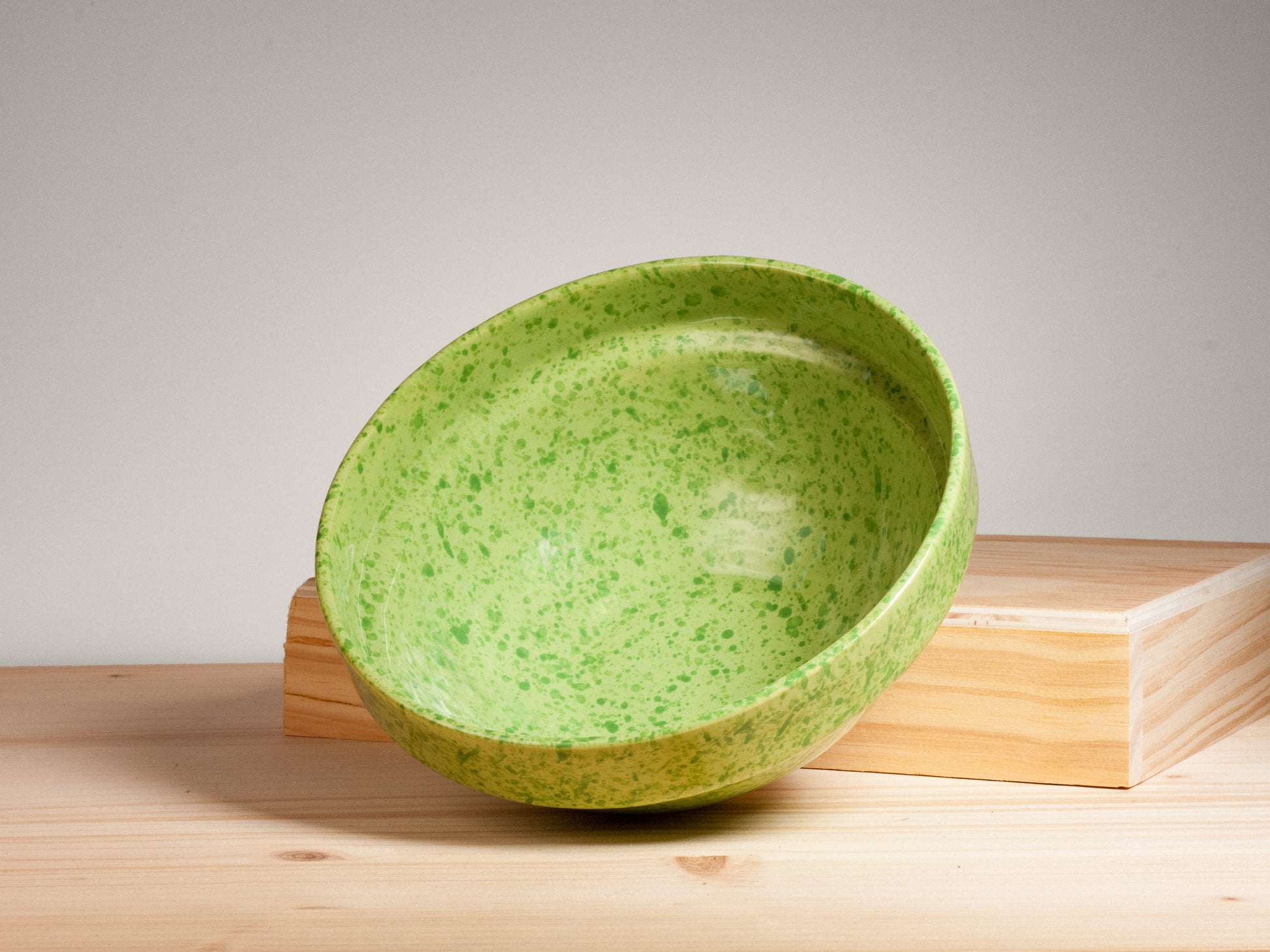 Green ceramic bowl on wooden surface