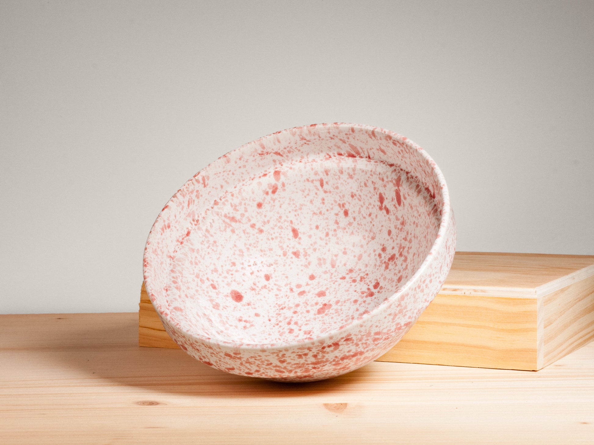 Pink and white ceramic bowl on wooden surface