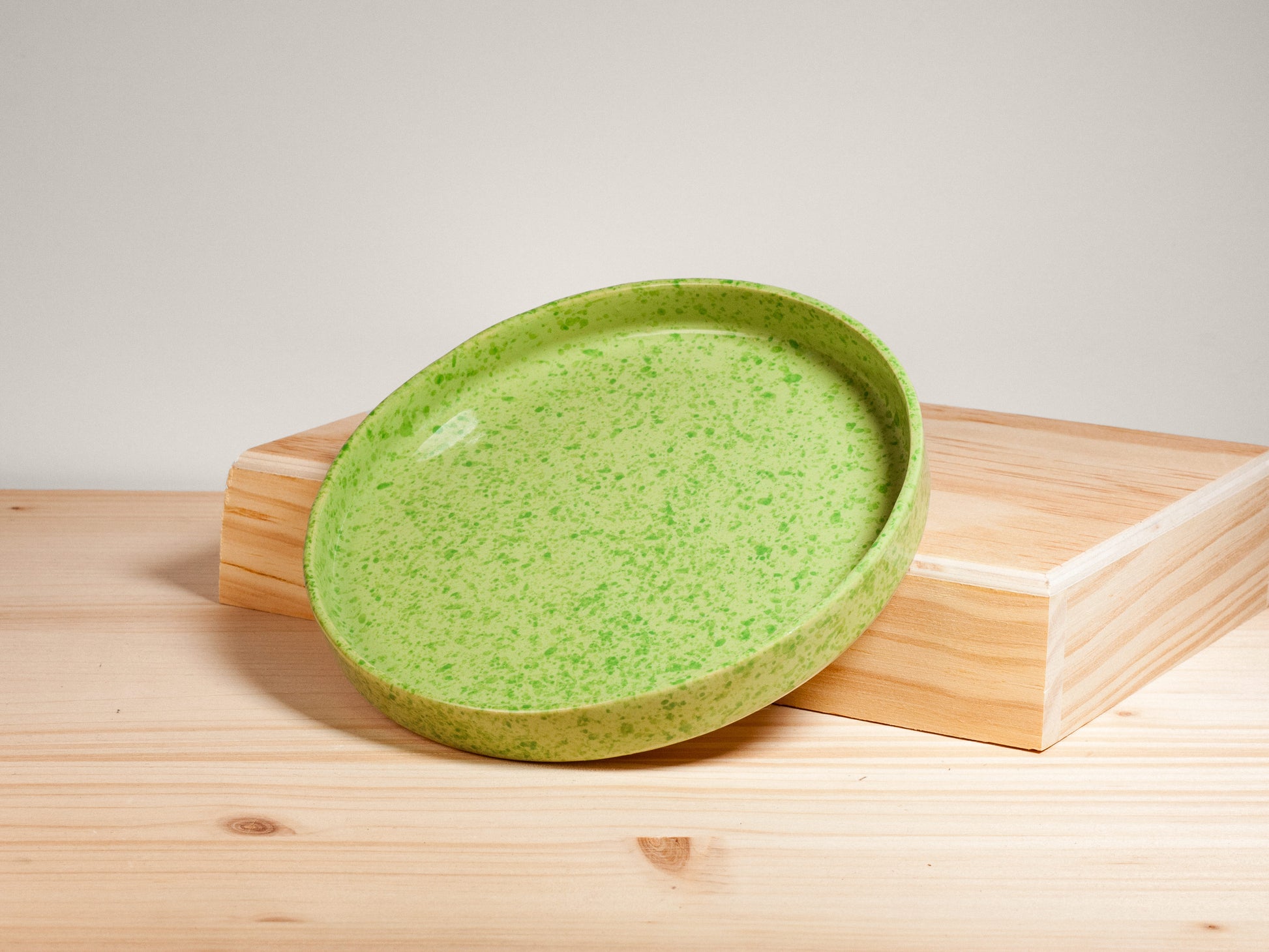 Green ceramic plate on wooden surface