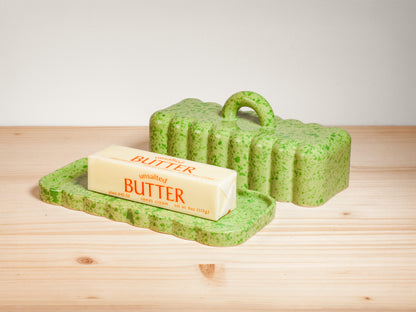 Green ceramic butter dish on wooden surface