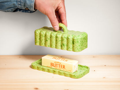Green ceramic butter dish on wooden surface