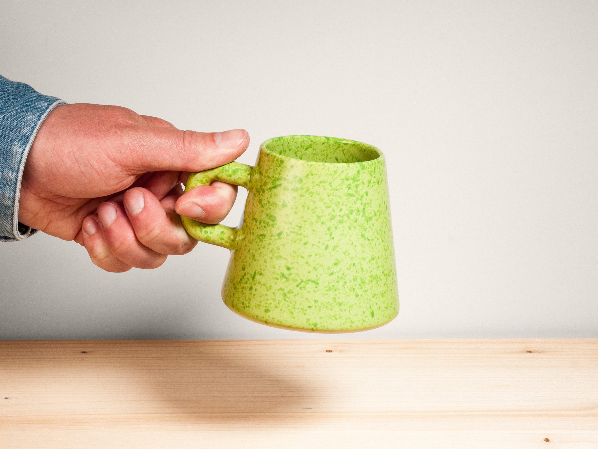 Green ceramic mug on wooden surface