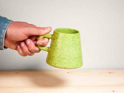 Green ceramic mug on wooden surface
