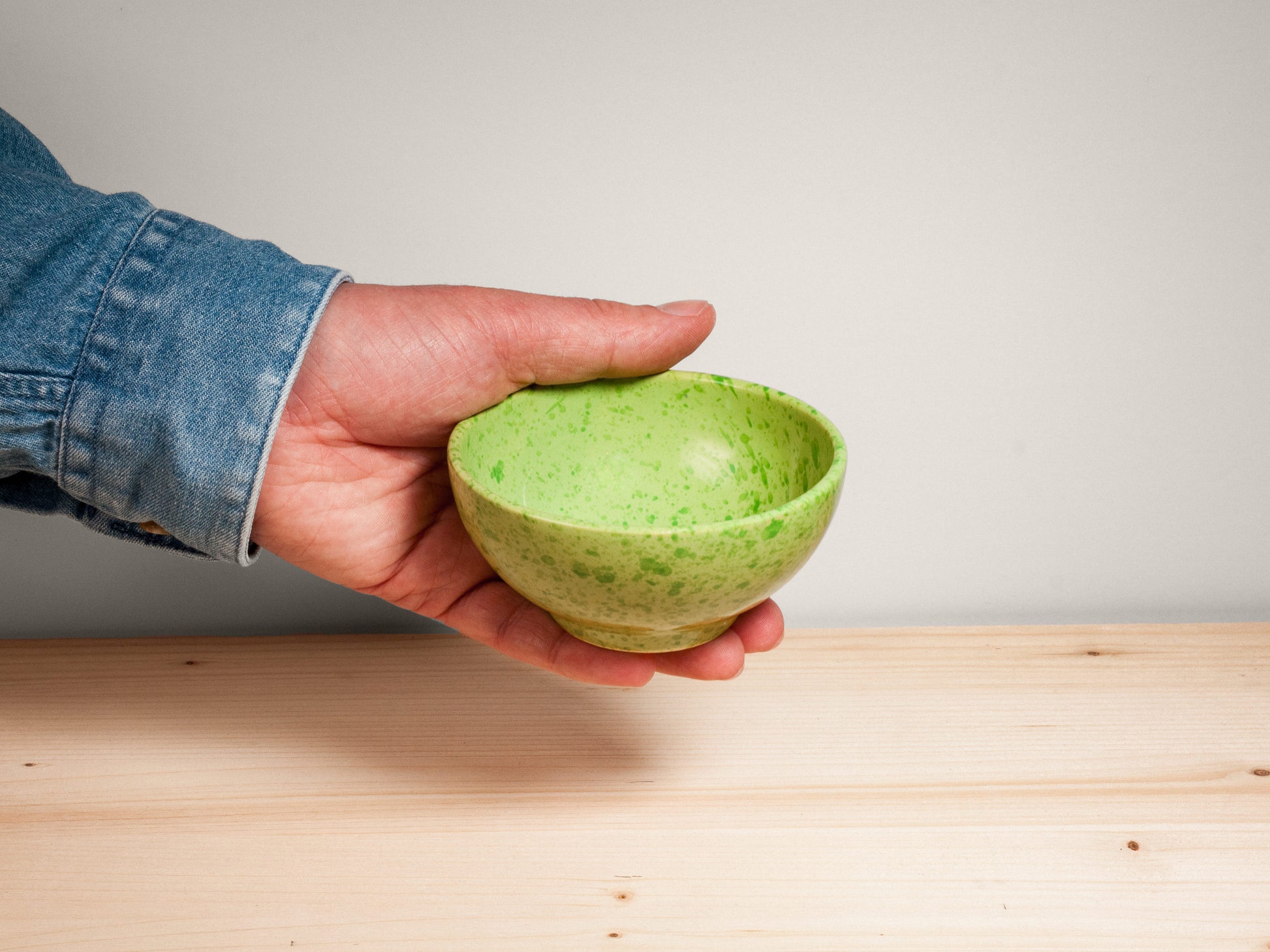 Green ceramic bowl on wooden surface