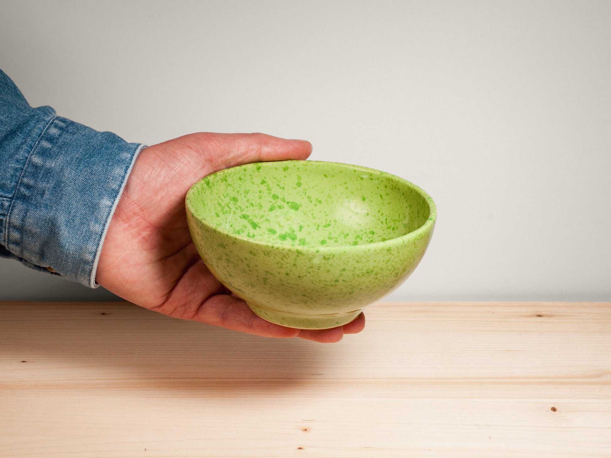 Green ceramic bowl on wooden surface