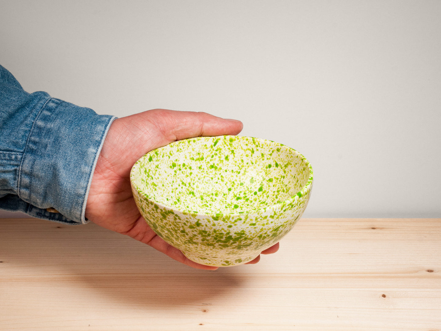 Green and white ceramic bowl on wooden surface