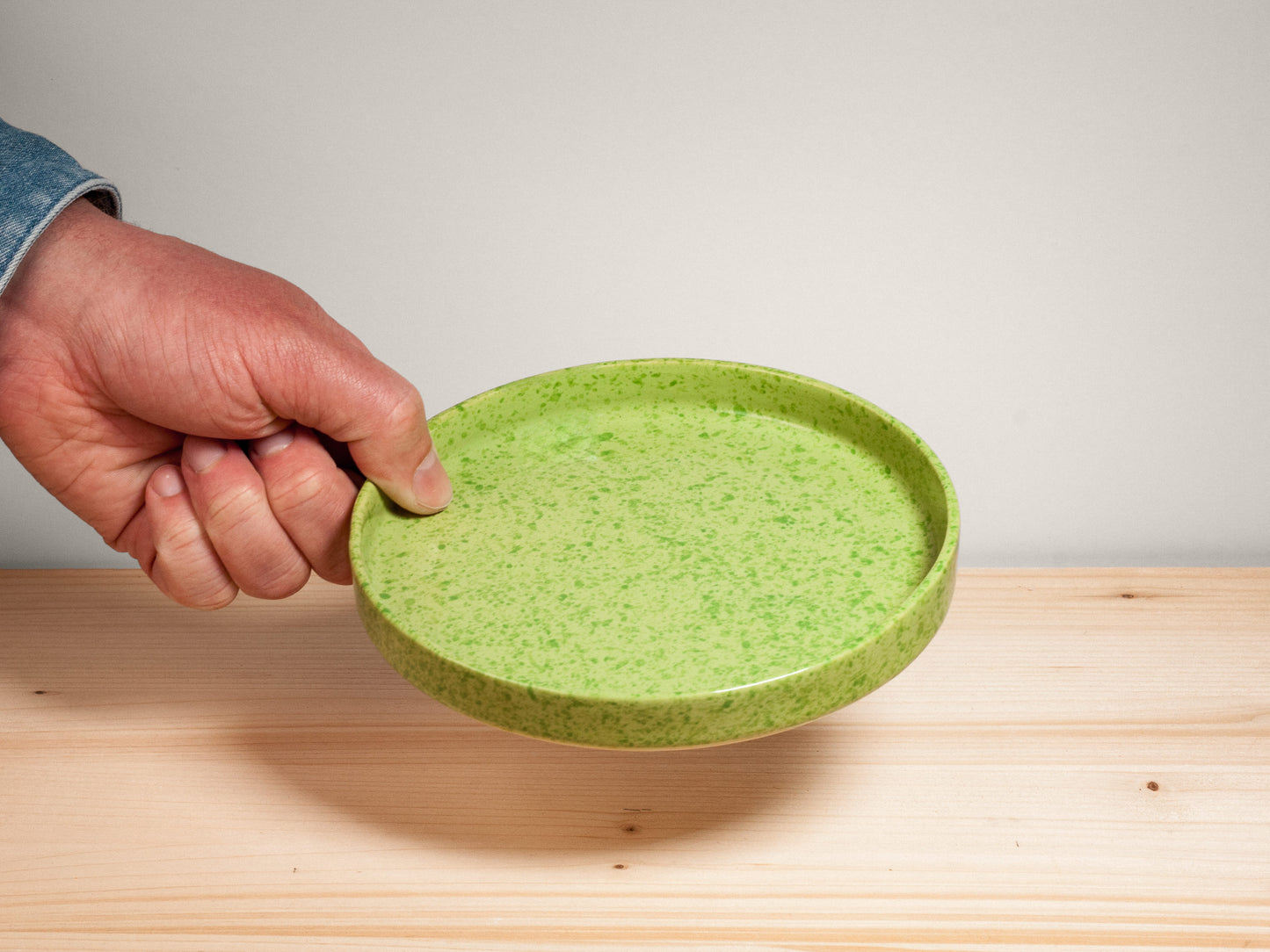 Green ceramic plate on wooden surface