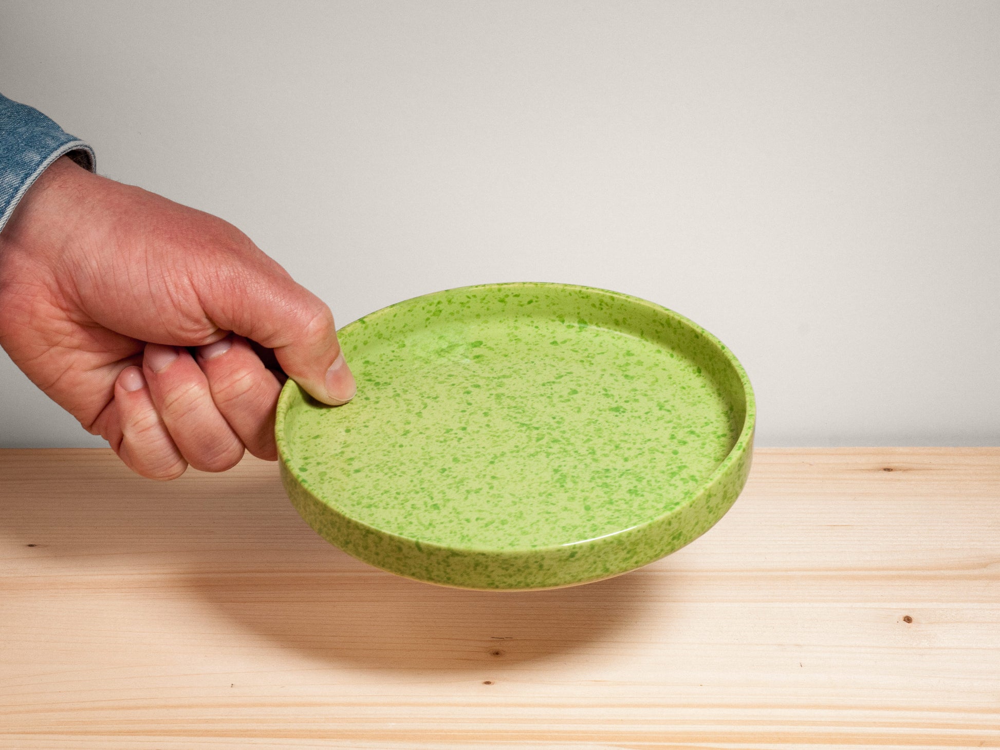 Green ceramic plate on wooden surface