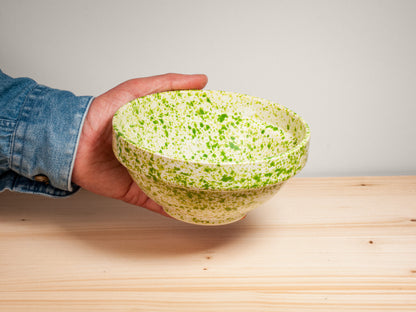 Green and white ceramic bowl on wooden surface