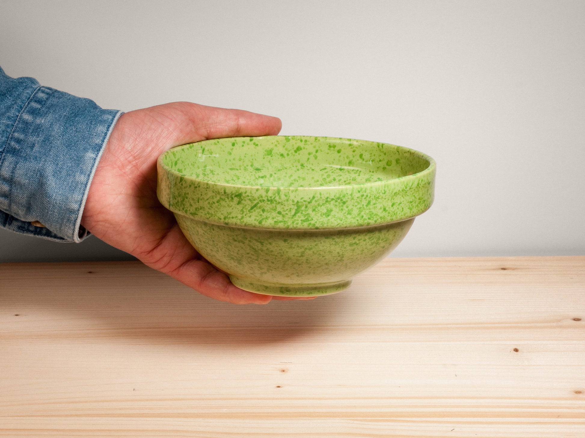 Green ceramic bowl on wooden surface