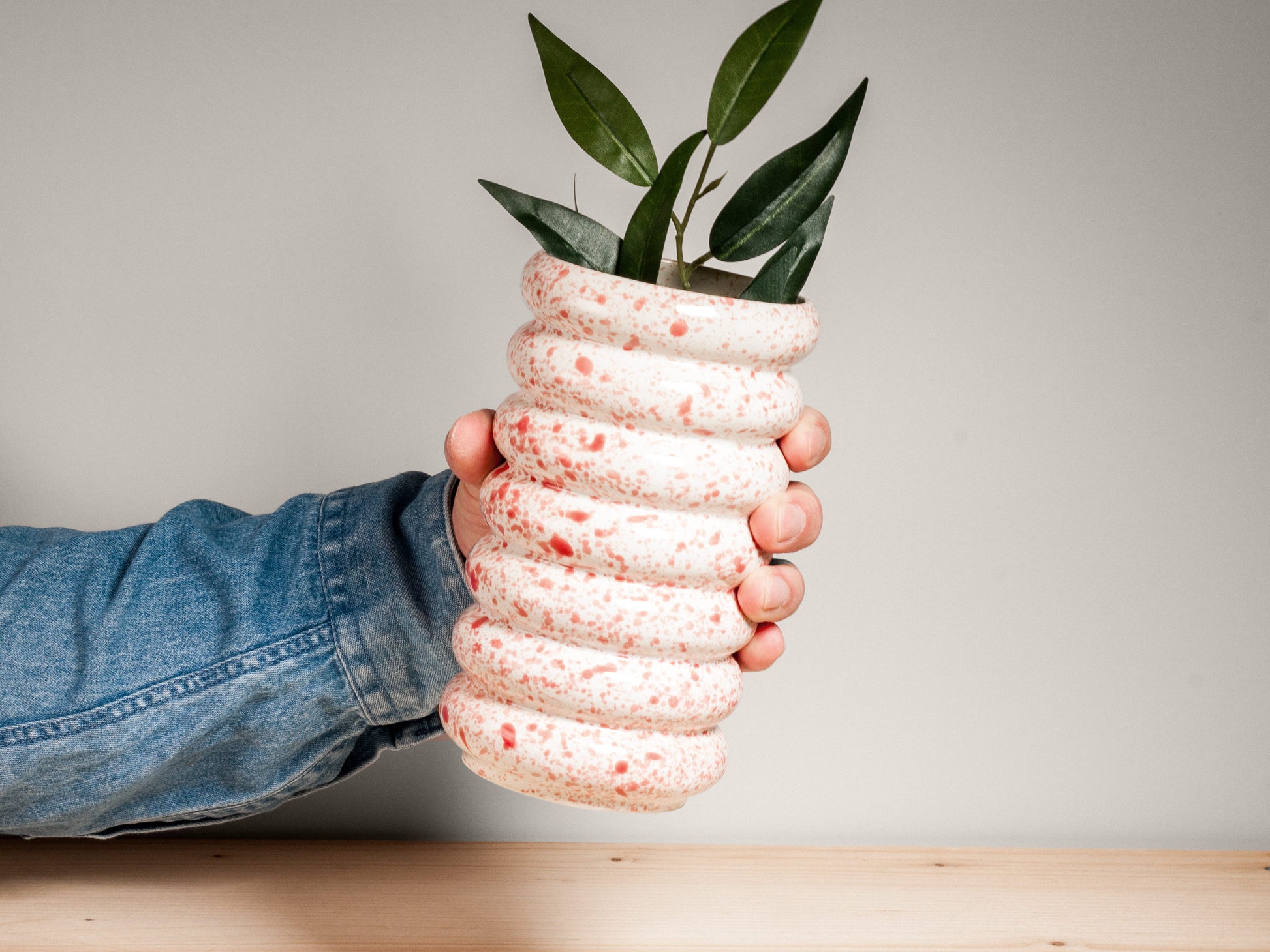 Pink and white ceramic vase on wooden surface