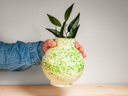 Hand holding large green ceramic vase