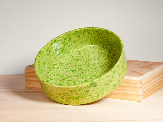 Green ceramic bowl on a wooden surface