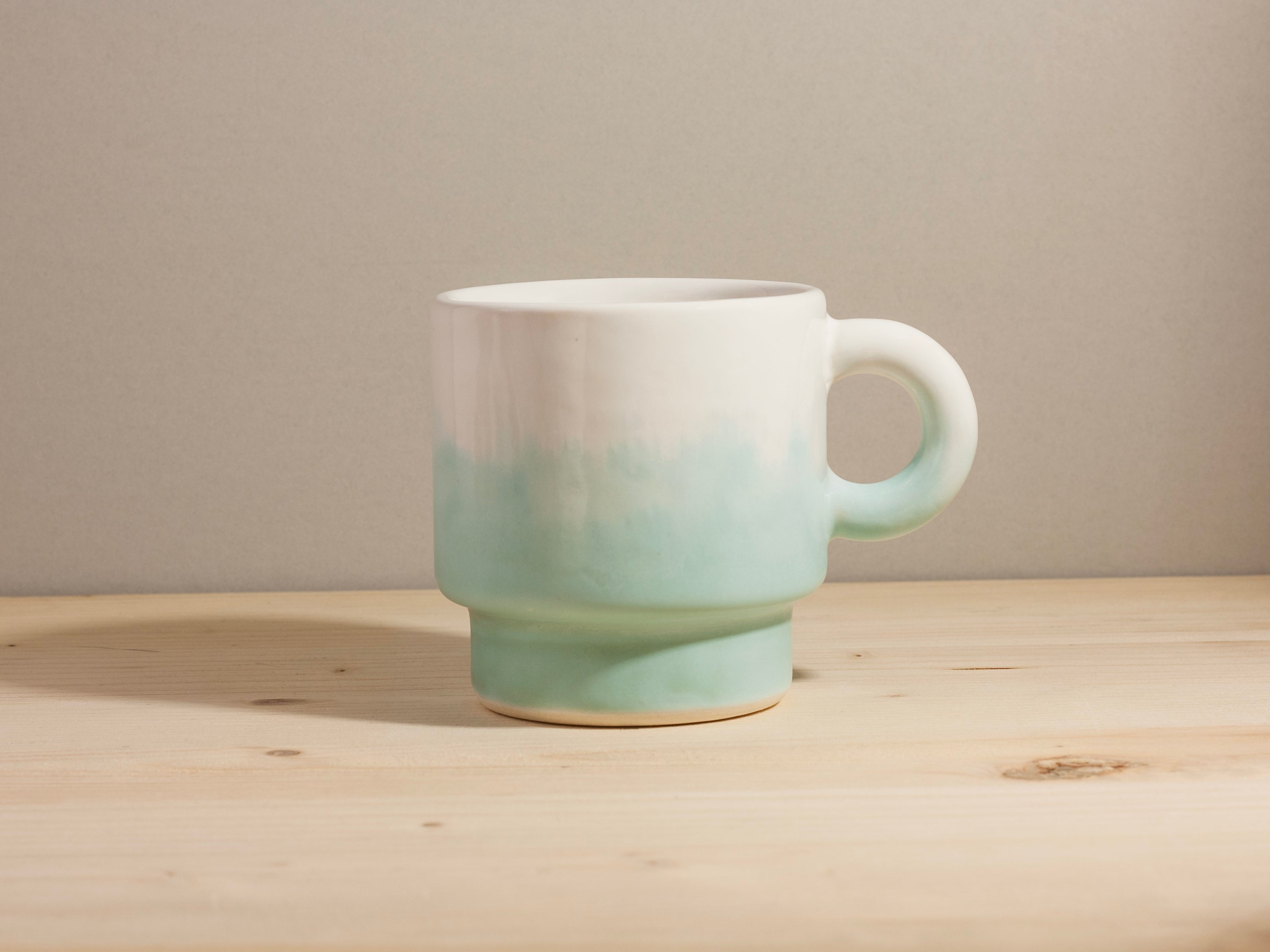 Ceramic mug with blue gradient design on a wooden surface