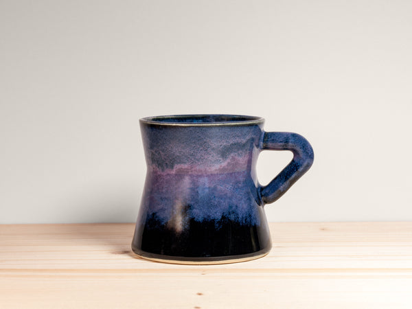 Blue ceramic mug on a wooden surface with a white background