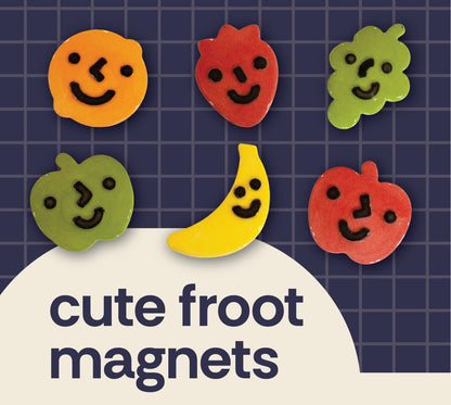 Six colorful fruit-shaped magnets with smiling faces are arranged on a dark blue grid background above a cream-colored curved shape. Large text reads 'cute froot magnets' 